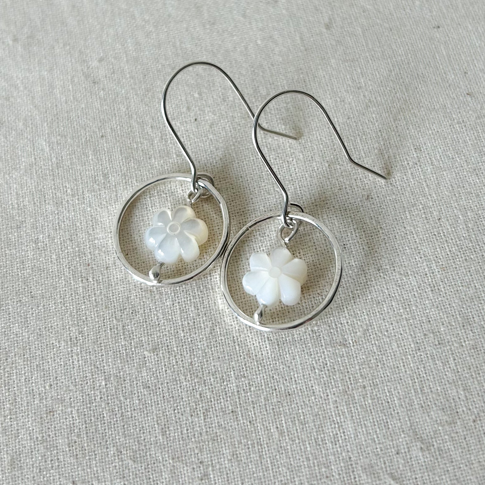 White flower earrings on gray background 