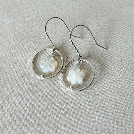 White flower earrings on gray background 
