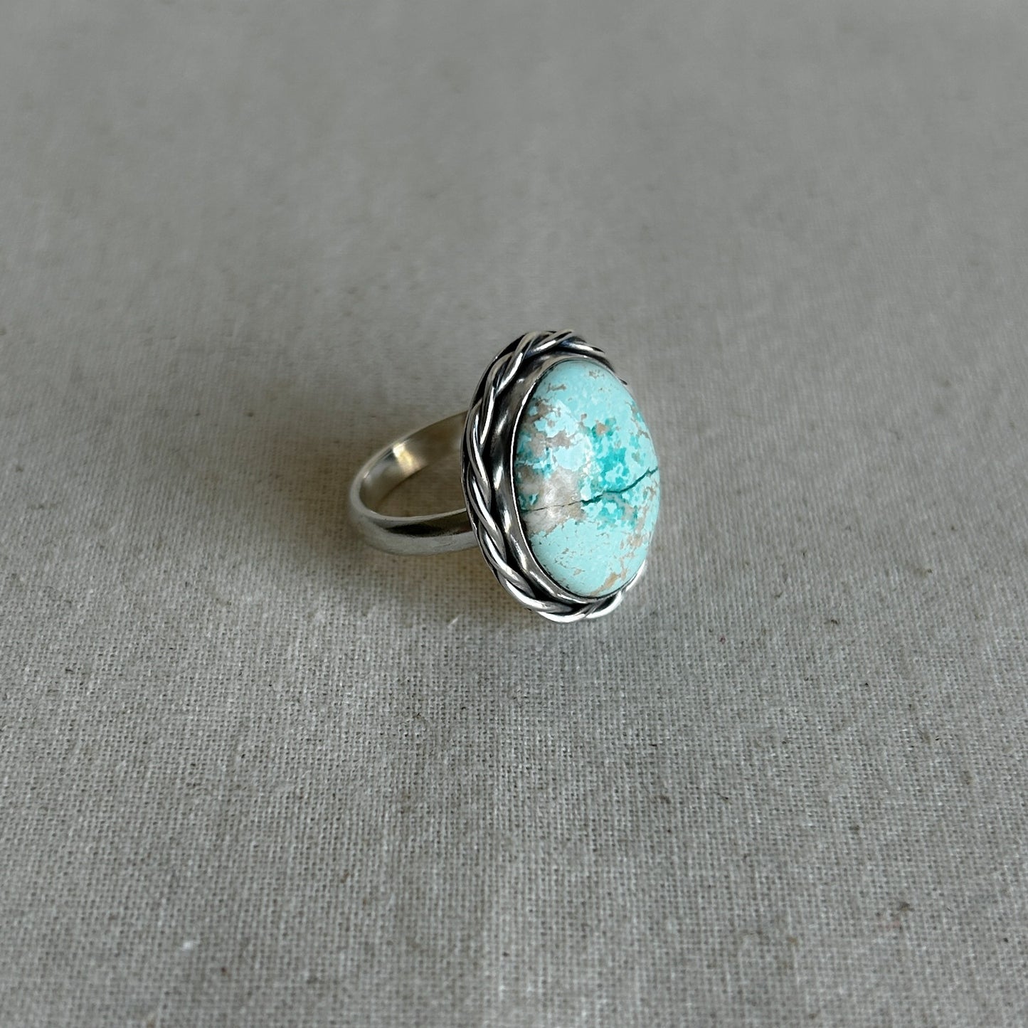 Oval turquoise ring with twisted silver wire border 