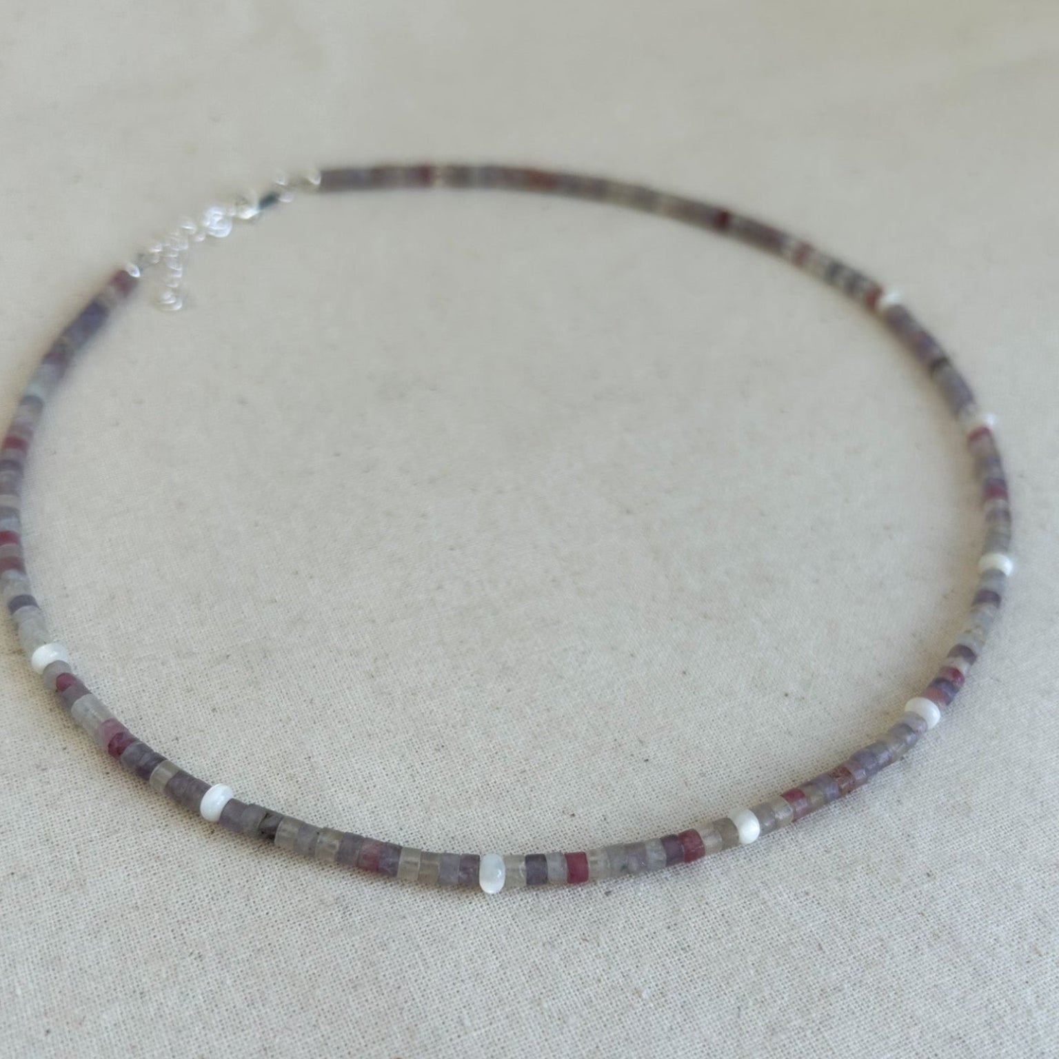 Necklace with multicolored beads on a beige surface