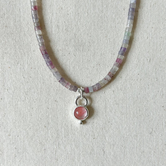Pink necklace on light gray background 