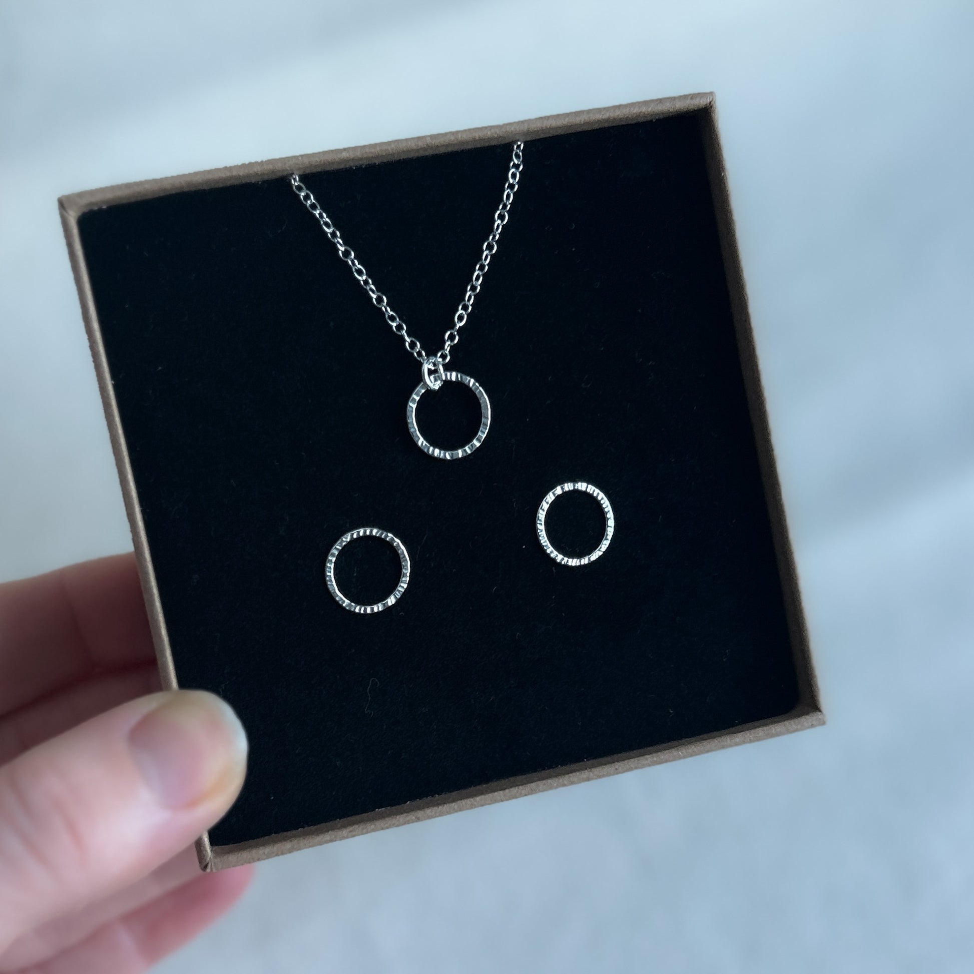 Silver pendant and bubble earrings displayed in a jewellery gift box. 