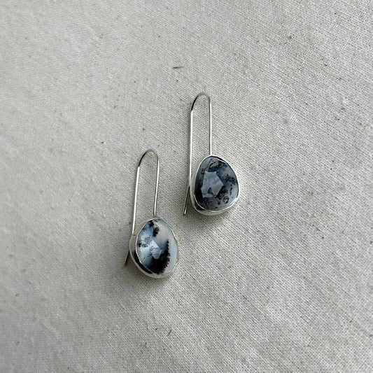 Silver dangle earrings featuring black and white opals