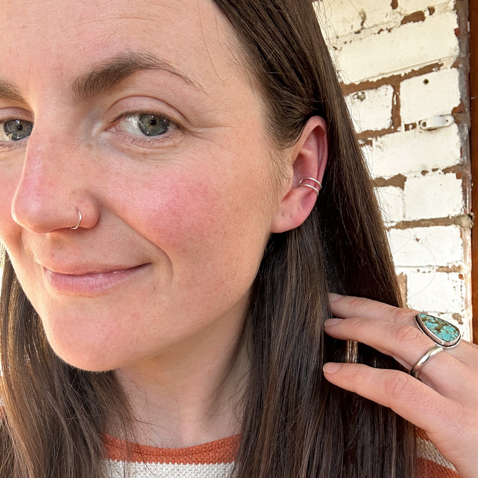 Model wearing a silver ear stacker in middle of ear 