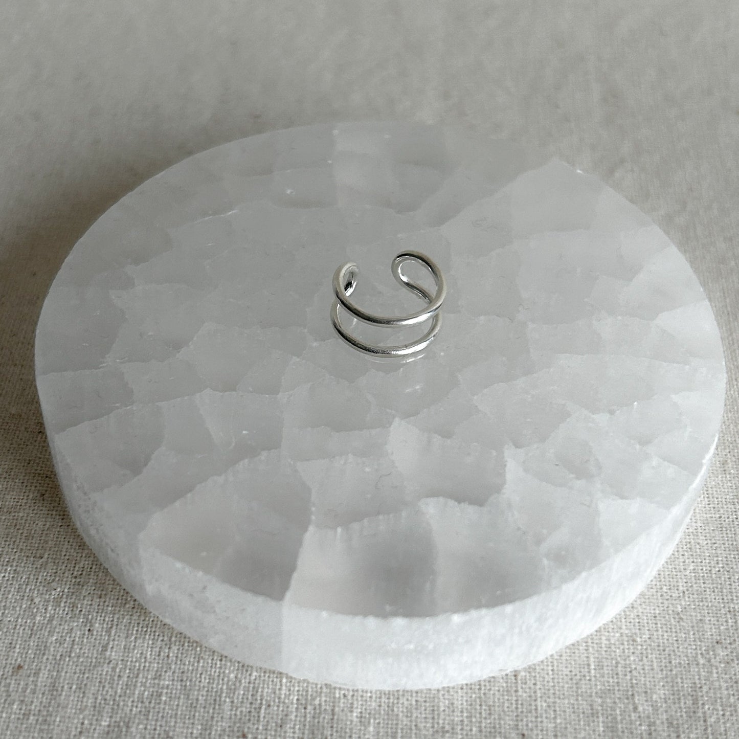 Shiny silver ear stacker on display table 