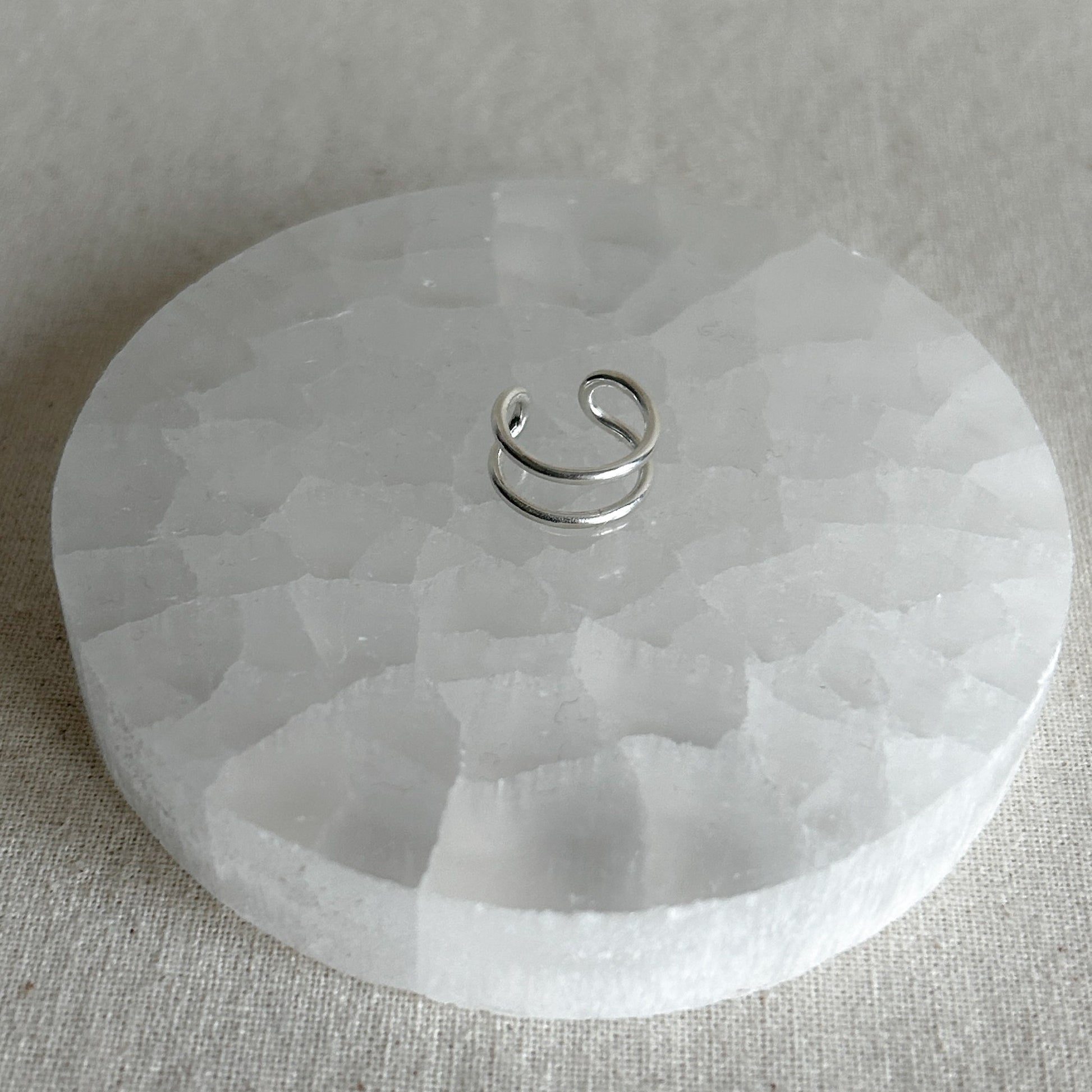 Shiny silver ear stacker on display table 