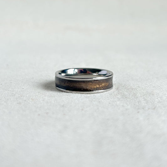 Silver ring with bronze inlay on a grey background