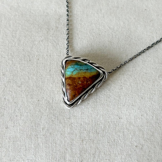 Brown and turquoise triangle pendant on grey background 