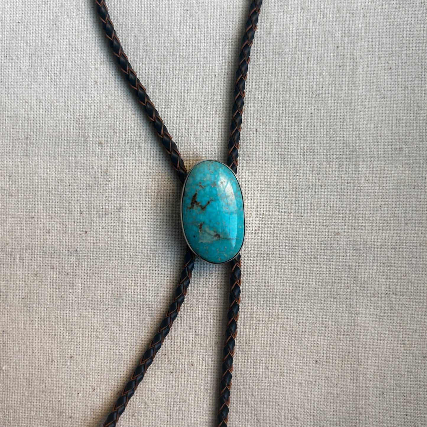 Freeform turquoise gemstone set in Argentium hanging on a leather cord necklace 
