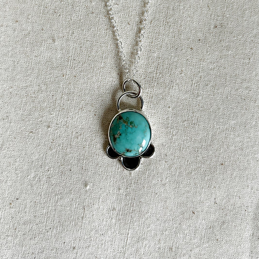 Round turquoise stone with 3 petal-like embellishments on a silver chain 