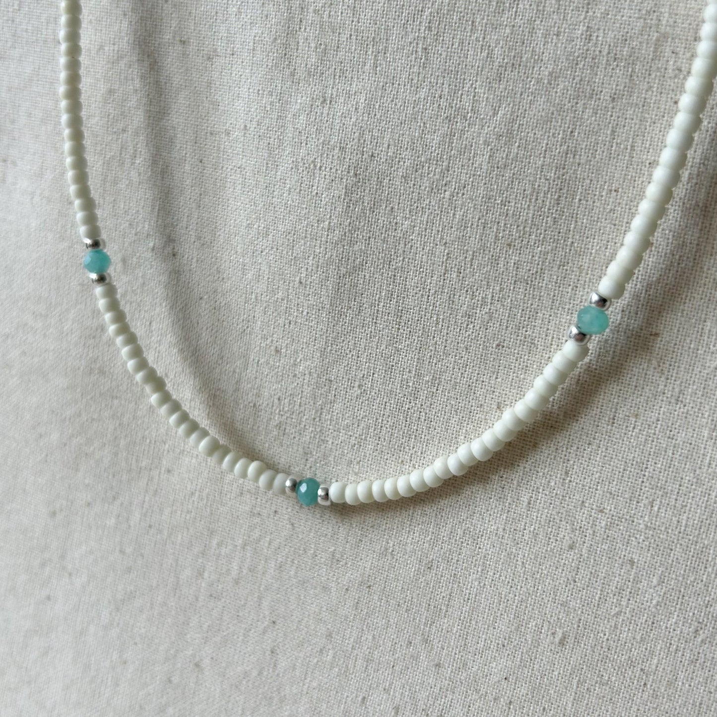 White beaded necklace with small blue beads
