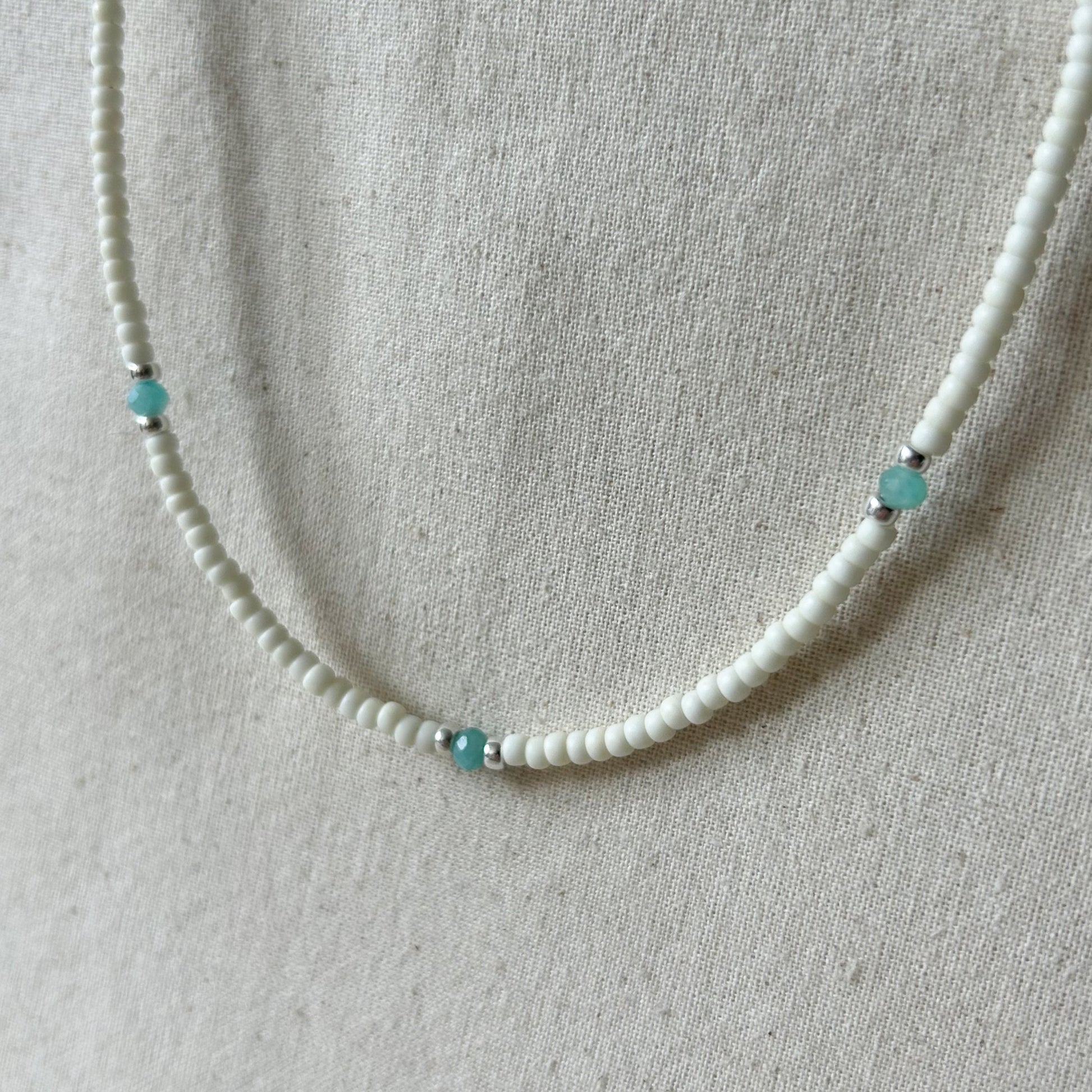 White beaded necklace with small blue beads