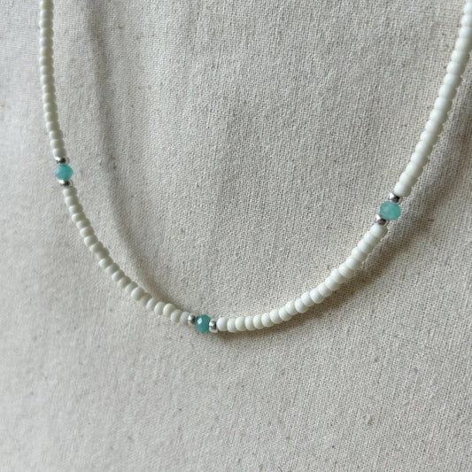 White beaded necklace with small blue beads